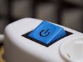 Blue power button on white extension cable. Power button, close-up shot Royalty Free Stock Photo