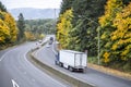 Blue professional industrial big rig semi truck transporting refrigerated cargo in reefer semi trailer running on the autumn Royalty Free Stock Photo