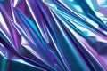 Blue and purple crumpled iridescent holographic foil texture background with shiny light reflections