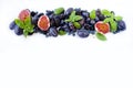 Blue and purple food. Group of fresh fruits and berries with basil`s on a white background. Royalty Free Stock Photo