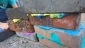 Little boy laying coloured putty between building bricks