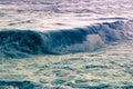 Blue purple swirling sea wave floods the shore, a surreal seascape