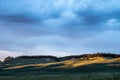 Blue and Purple Tinted Clouds Over Rolling Hills At Sunset