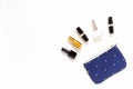 Blue purse with golden perfume, white and black nail polish and black lipsticks with copy space