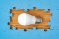 Blue puzzle border with a bright light bulb in the middle Royalty Free Stock Photo