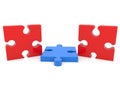Blue puzzle piece in the middle between two red puzzle pieces Royalty Free Stock Photo