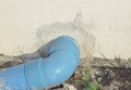 Blue pvc drainage pipe outside the concrete wall.Blue PVC drainage pipe drains into the ground