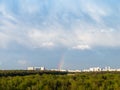 Blue rainy clouds and rainbow over city in spring Royalty Free Stock Photo