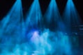 Blue rays of light from the spotlights through the smoke on the stage. Theatrical performance. Defocused abstract image