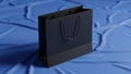 Blue rectangular shopping bag with black handles is positioned Royalty Free Stock Photo
