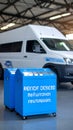 Blue recycling bins with wheels in a warehouse, in front of a white delivery van. Royalty Free Stock Photo