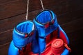 Blue and red boxing gloves and bandage on brown plank background. Royalty Free Stock Photo