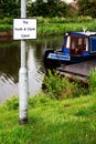 Blue and red canal boat moored in the Forth & Clyde Canal, Scotland