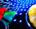 Blue and red cocktail with golden sparkling disco ball background selected focus