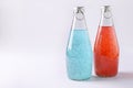 Blue and red drinks with basil seeds or falooda seeds or tukmaria in bottles on white background, Copy space Royalty Free Stock Photo