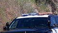 Blue and red flashing light on the top of a black police car