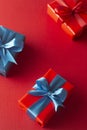 Blue and red gift boxes with red ribbon and bow isolated on red background, top view. Christms, party concept