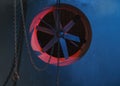 Blue and red neon light on Ventilation system fan and chains with hook