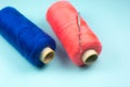 Blue and Red spools of thread with a needle, close up Royalty Free Stock Photo