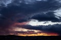 Blue-red sunset with dark gloomy clouds over the city. Dark silhouette of the city with a beautiful blurred dawn. Artistically Royalty Free Stock Photo