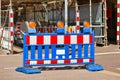 Blue, red and white striped construction site barrier with construction works