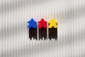 Blue, red and yellow figures of people on a striped background, three figures of people of different colors in a row in the center