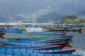 A Blue red yellow green old wooden boats on the water. rowing boats on the lake against the backdrop of green mountains