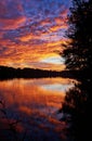 Blue, red, yellow, green and orange sunset sky at the forest lake and reflection in the lake Royalty Free Stock Photo