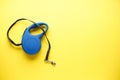 Blue retractable dog leash on a yellow background, with space for text. Flat lay Royalty Free Stock Photo
