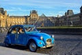 Blue retro car in front of the Louvre