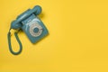 Blue retro telephone seen from a high angle on a yellow background Royalty Free Stock Photo