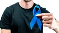 Blue ribbon. Awareness prostate cancer of men health in November. Hipster men in black shirt with blue ribbon in hands isolated on Royalty Free Stock Photo