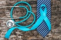 Blue ribbon symbolic of prostate cancer awareness campaign and men`s health in November month on necktie, doctor`s stethoscope