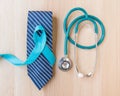 Blue ribbon symbolic for prostate cancer awareness and men`s health in November month on necktie, doctor`s stethoscope