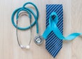 Blue ribbon symbolic of prostate cancer awareness and men`s health in November month on necktie and stethoscope