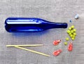 Blue riesling wine bottle, shrimp, grape brush, sushi sticks on a gray canvas background
