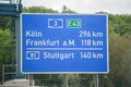 Blue road sign between Cologne, Frankfurt am Main and Stuttgart