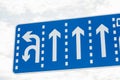Blue Road Sign with white lines showing direction