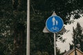 Blue road traffic sign pedestrian and bicycle zone on green trees background. Royalty Free Stock Photo