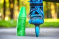 Blue roller skates with slalom cones lying on asphalt.