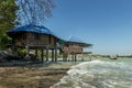 blue roofed bungalows suspended on stilts over the water near