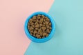 Blue round feeding bowl with dark brown heart shaped pet kibble