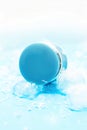 Blue round plastic container with cosmetic substances, on blue background with ice cubes and snow. Royalty Free Stock Photo