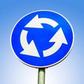 Blue roundabout crossroad road traffic sign against blue background