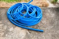 The blue rubber hose for watering the garden is placed on the ground Royalty Free Stock Photo