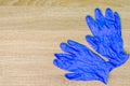 Blue rubber medical gloves lie on wooden table. Concept of hygiene and protection of human hands. Copy space for text. Top view