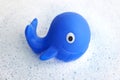 Blue rubber whale on white soap foam Royalty Free Stock Photo