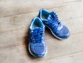 Blue running shoes laid on a wooden floor Royalty Free Stock Photo