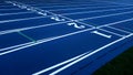 Blue Running Track with White Lane Numbers and Green Turf Royalty Free Stock Photo