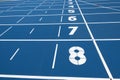 Blue running treadmill track with lane numbers in stadium outdoors Royalty Free Stock Photo